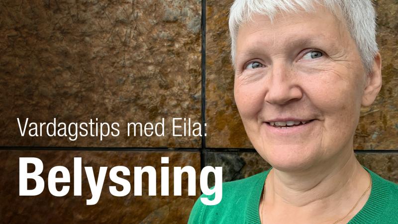Eila har kort, grått hår och står framför en rostbrun vägg. Hon ser glad  ut.