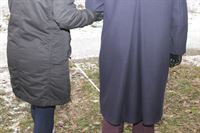 Bilden föreställer en person som håller en annan person under armen