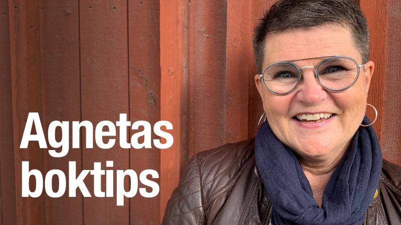 Agneta har mörkt, kort hår, glasögon med mörka bågar och en brun skinnjacka. Hon står framför den faluröda väggen på Kulturens hus i Luleå.