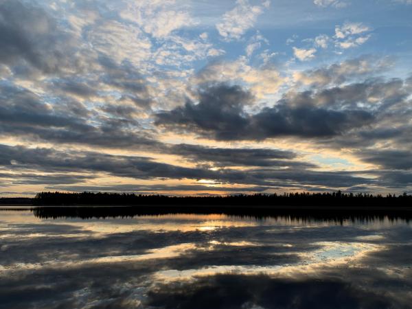 Molnen speglas i vattnet i blå toner