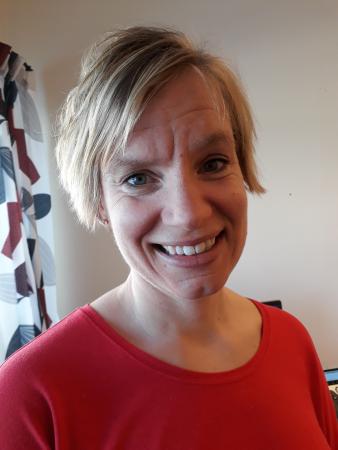 karolina har kort, ljust hår och ser glad ut på bilden.