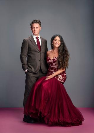 Anna-Lotta har långt mörkt, lockigt hår och bär en röd galaklänning. Andres har mörkt , kort hår och är klädd i en grå kostym.