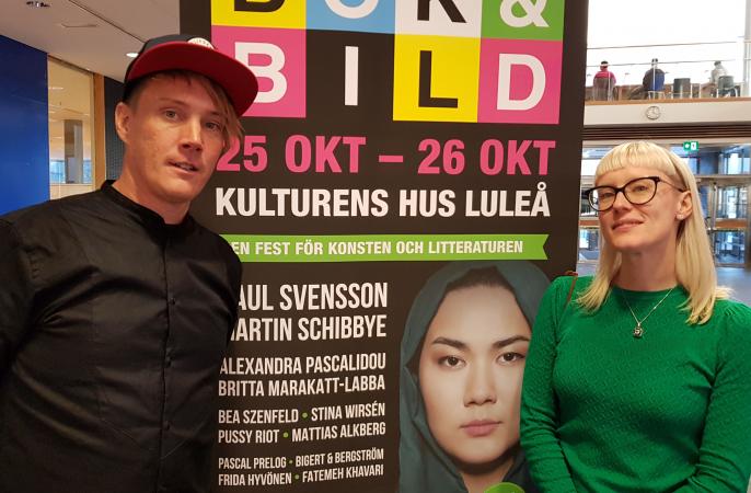 Projektledarna David Jordansson och Sara Pietikäinen står på var sin sida om en stor affisch med reklam för Bok och bild.