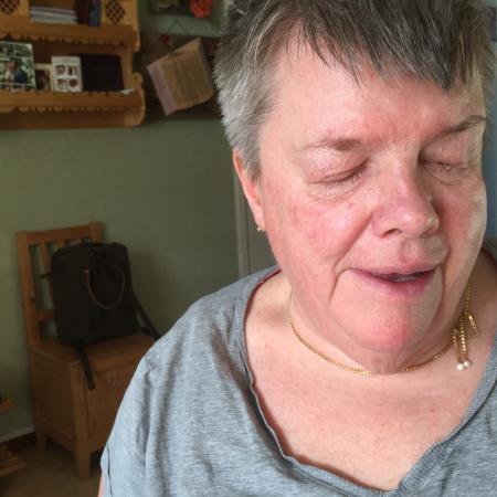 Anita har grått kort hår och en grå tröja.