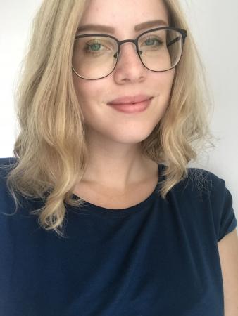 Julia Gatu går på Sociologiprogrammet på LTU. Hon har axellångt blont hår och stora glasögon. Julia ler på bilden och hon har en svarttröjamed korta ärmar.